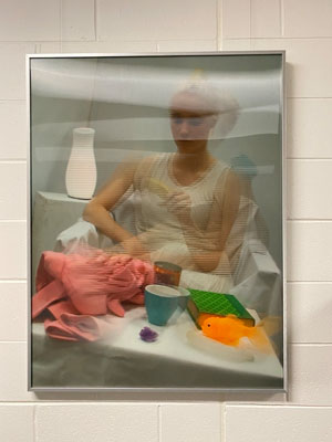lenticular painting of a women sitting on a chair holding an item in her hands