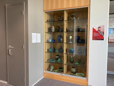 beige-colored cupboard with shelves filled with pottery