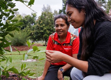 Indigenous lecturer teaching a student about plants