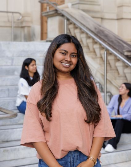 Indian student outside CBD campus smiling. 