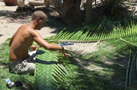 man weaving palm leaves