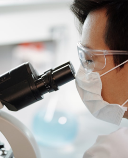 Researcher looking through a microscope