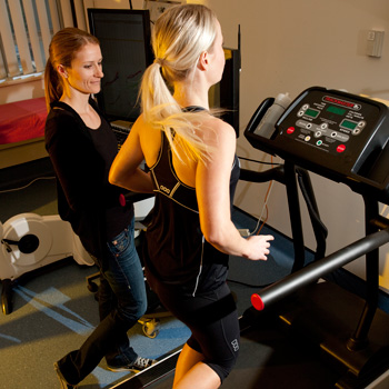 exercise physiologist checking on a runner on a treadmill