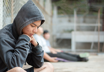 Teens leaning at a wired fence