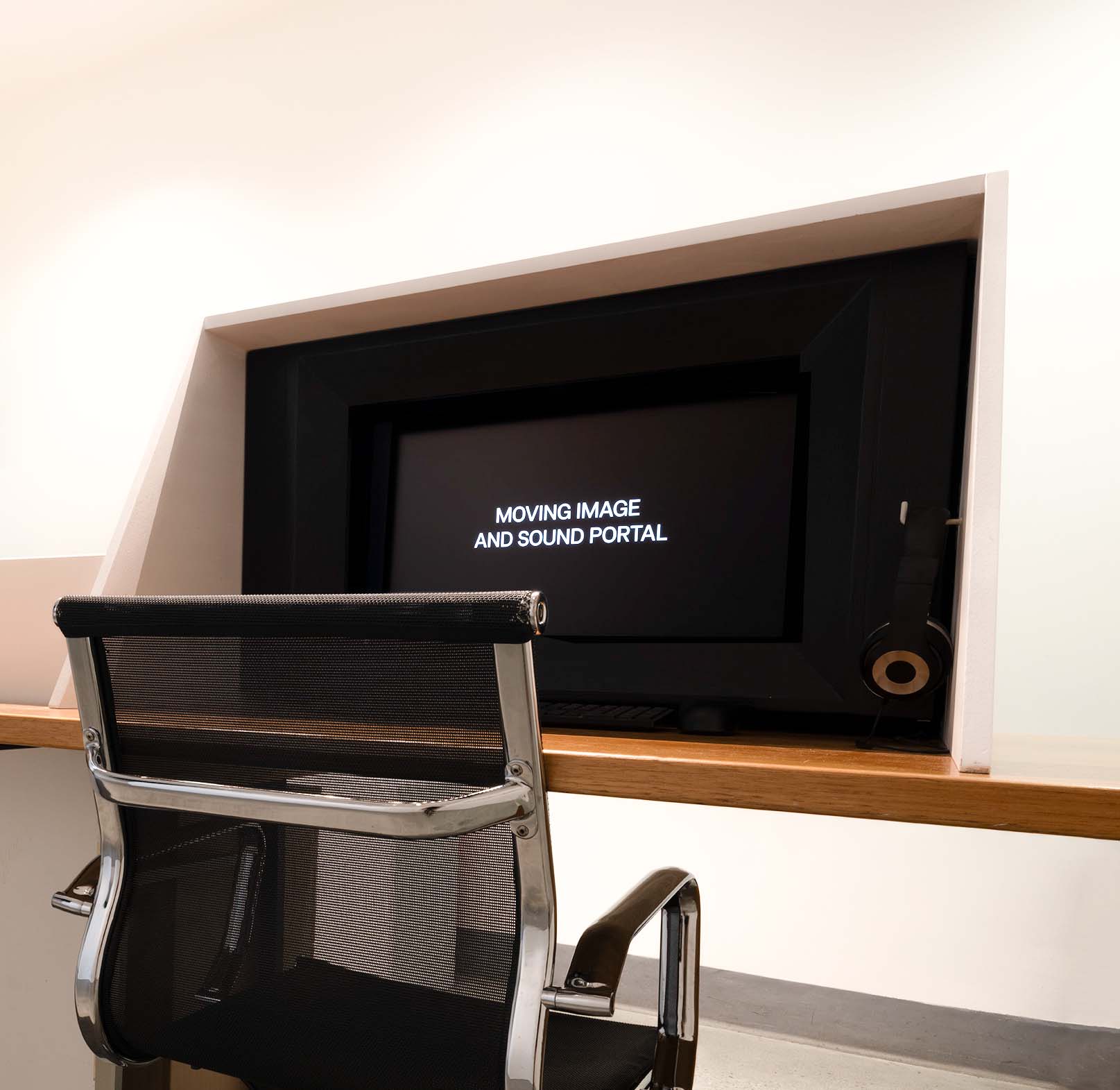 A chair in front of a computer screen that reads 'MOVING IMAGE AND SOUND PORTAL