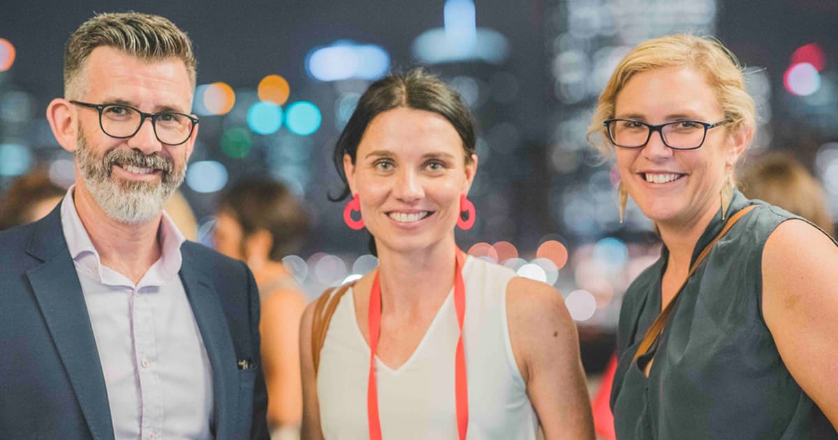 Three people dressed nicely and smiling at the camera