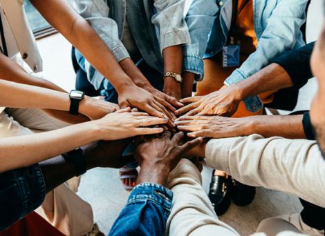 A group of diverse people with hands joining together