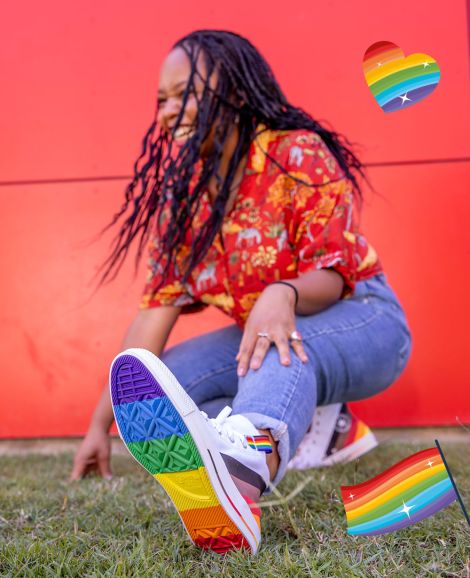 student posing with rainbow shoes