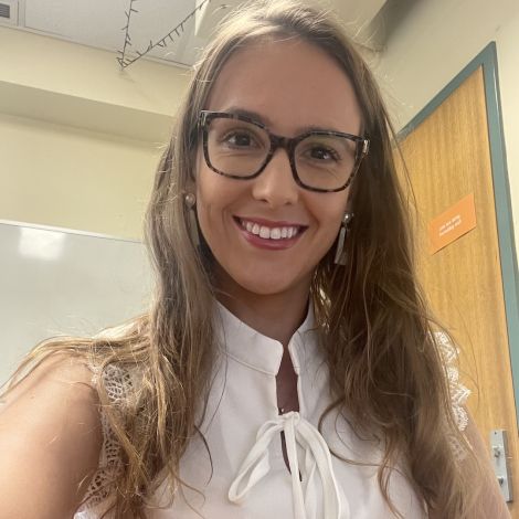 Image of Dr Renata Mendes smiling while sitting at desk.