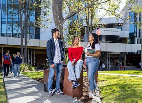 A small diverse group of students standing in front of Griffith university