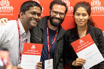 Three students holding certificates