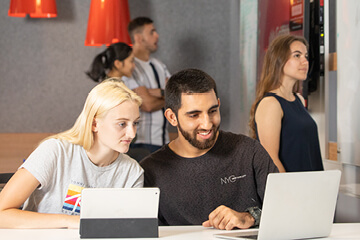 Two students looking at a laptop