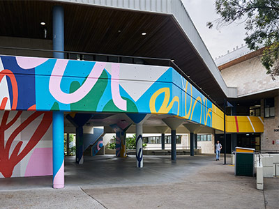 bright-coloured mural spanning the N65 buidling and its undercroft