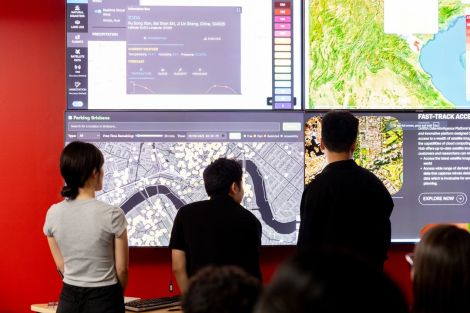 Group of students standing in front of a large digital screen