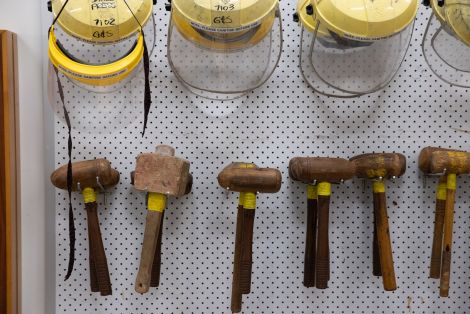 Face shields and hammers hanging on the wall in the QCA jewellery studio