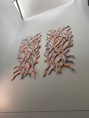 wall art made up of two flame-inspired mirror-image sculptures