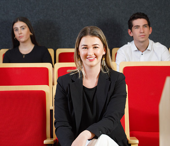 Woman smiling at camera with teammates behind her