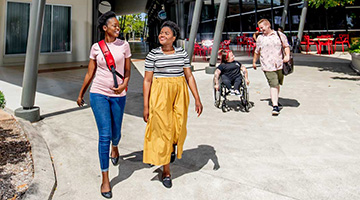 Students walking around campus one of them in a wheelchair