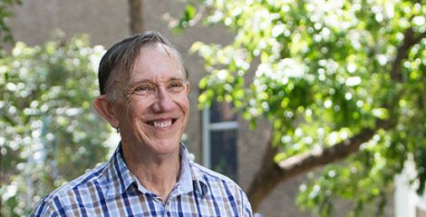 Man smiling with trees behind him