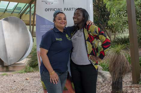 Two women standing and embracing one another