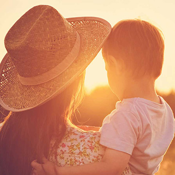 Mother holding her child looking into the sunset