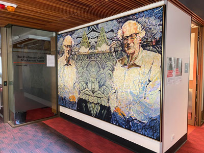 a painting of a man and his mirror image spanning across the wall next to an automatic door