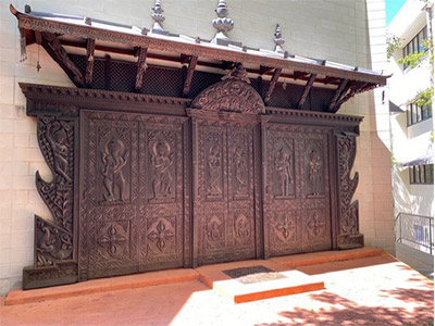 a dark brown Hindu temple style doorway placed against a wall outside N06 building