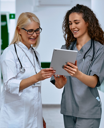 Two health professionals checking a document on a tablet