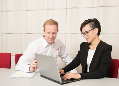 Two Griffith staff member working together on a laptop