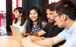 Photo of GELI students sitting at a desk in front of a laptop