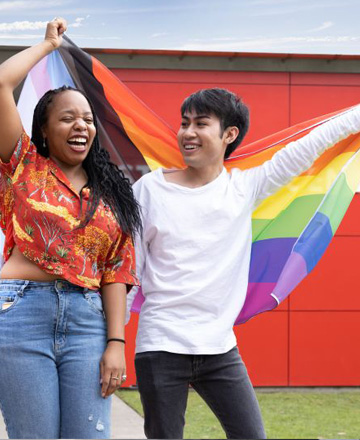 Two students holding a rainbow flag
