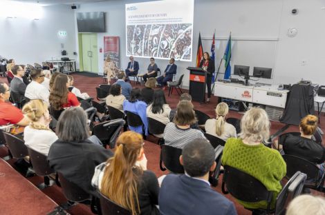 Group of adults watching presentation in lecture theatre