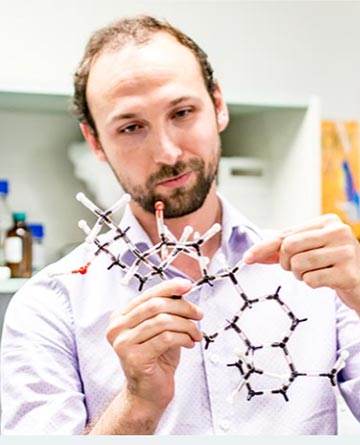 a scientist buidling a chemical structure using a modeling kit