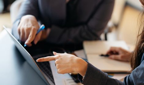 Businessman and businesswoman working with laptop in office