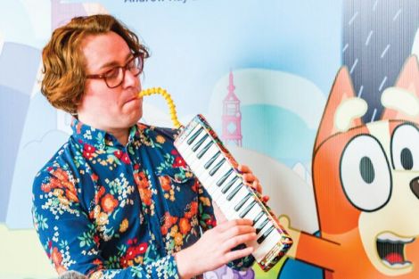 Joff Bush playing Melodica in front of Bluey wall mural