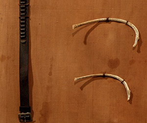 Intersecting histories: Bone poem stretcher (detail), Melissa Stannard, WW2 Field stretcher, leather ammunition belt, three kangaroo rib bones with poetry written in 0.005-micron pen