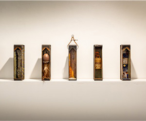Remembrances: Tribute Tins, 2023. Melissa Stannard, Series of seven World War Two ammunition tins and found objects, approx. 10cmW 42cmH 12cmD each. Photo Michelle Vine.