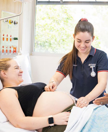 female students taking an ultrasound for a pregnant woman