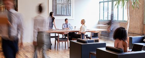 A group of professionals sitting and walking around a room