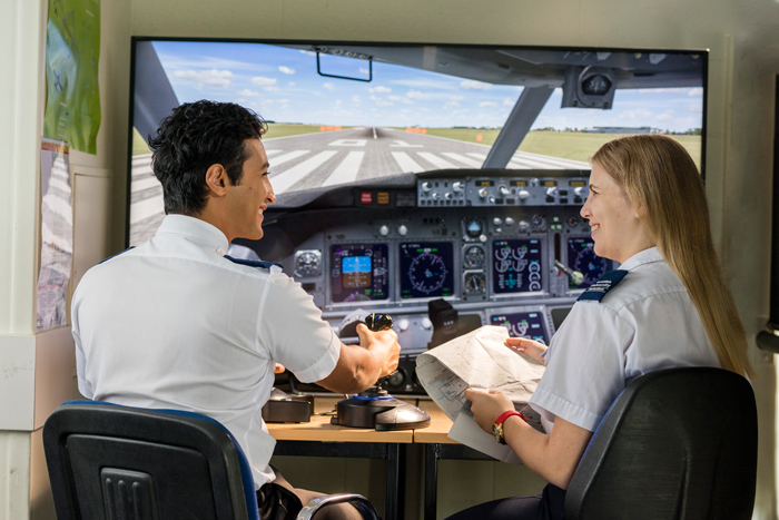 Two students operating on aviation flight simulators