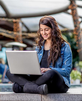 Student outside using laptop